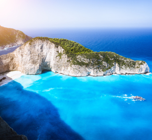 Blick auf den ber&uuml;hmten Navagio-Strand (Schmugglerbucht) auf Zakynthos mit t&uuml;rkisblauem Wasser, wei&szlig;em Sandstrand und steilen Klippen.