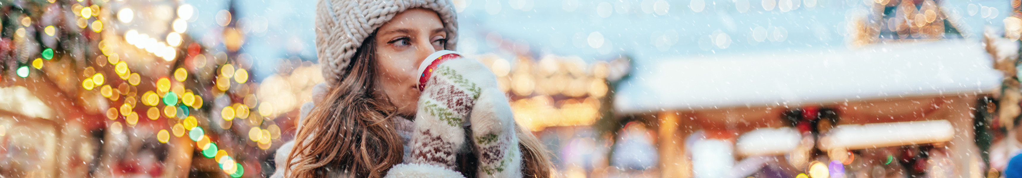 Frau trinkt Gl&uuml;hwein auf Weihnachtsmarkt