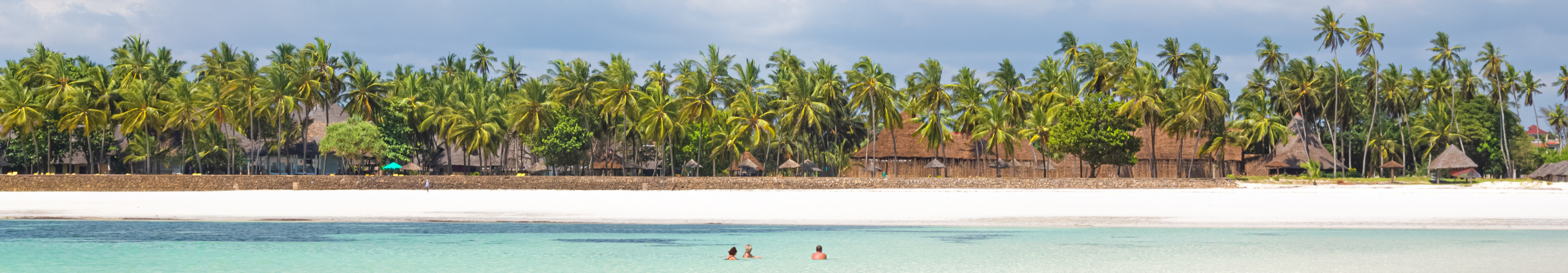 Diani Beach in Kenia mit feinem wei&szlig;en Sand, klarem Wasser und Palmen entlang des Ufers.