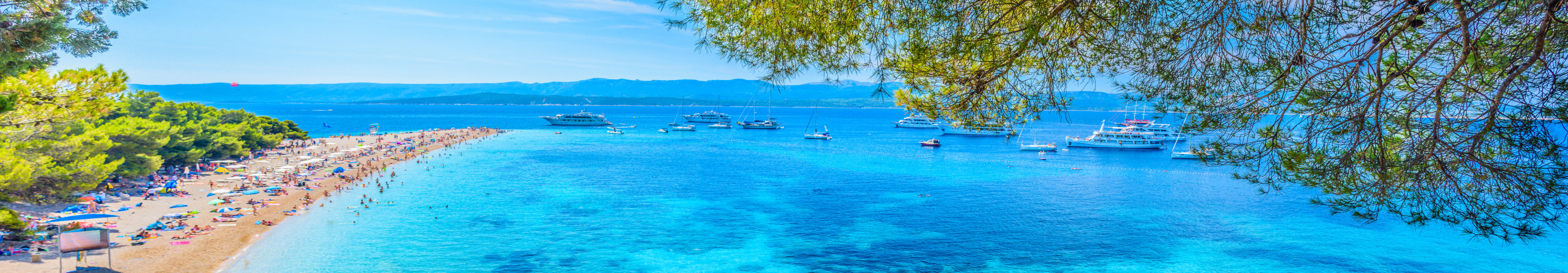 Bekannter Strand Zlatni Rat auf der Insel Brač in Kroatien mit türkisblauem Wasser, Yachten und Badegästen