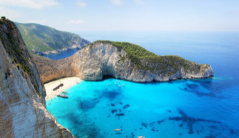 Panoramablick auf die ber&uuml;hmte Navagio-Bucht auf Zakynthos mit wei&szlig;em Sandstrand, t&uuml;rkisem Wasser und umgebenden Steilklippen.