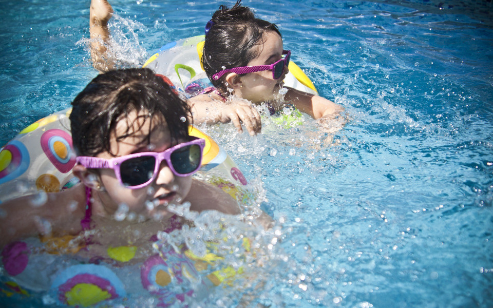 Kinder im Pool mit Schwimmreifen