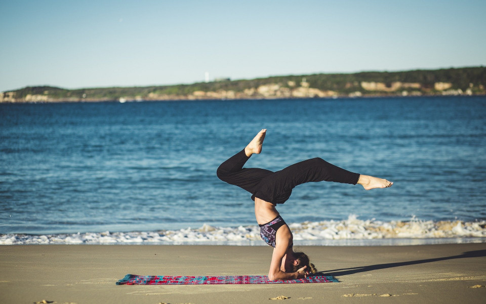 Frau macht Yoga am Meer