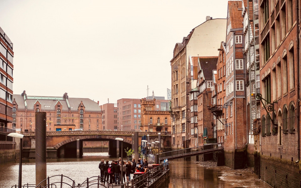Malerischer Blick auf die historische Deichstra&szlig;e in Hamburg, mit ihren traditionellen Kaufmannsh&auml;usern entlang eines Fleets, im Hintergrund die Speicherstadt mit ihren Backsteinbauten und Br&uuml;cken.