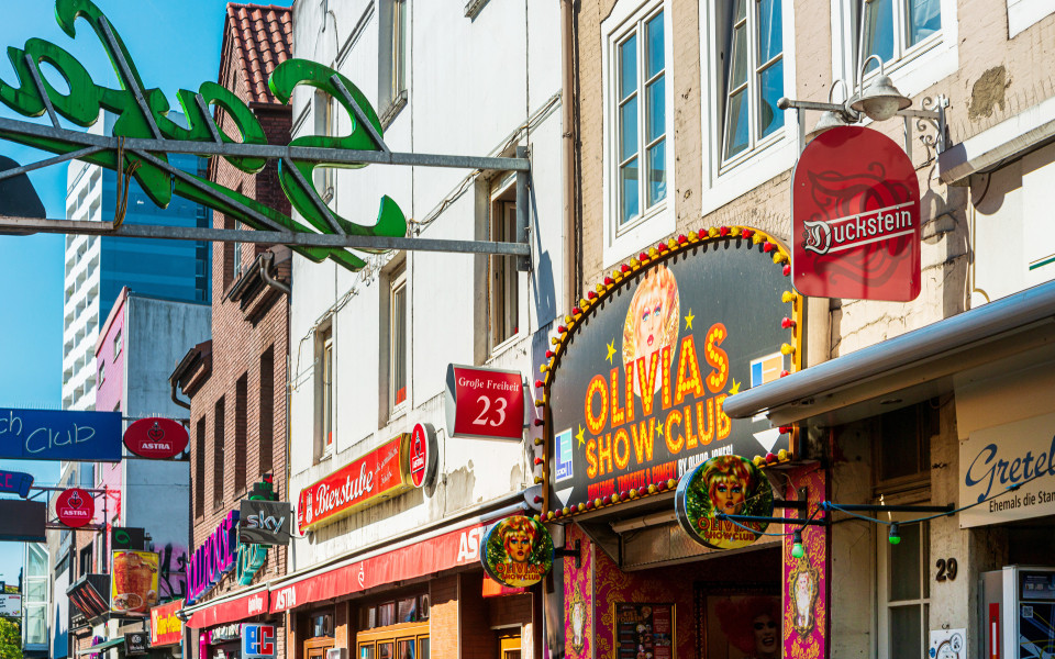 Gro&szlig;e Freiheit auf der Reeperbahn in Hamburg, eine lebendige Stra&szlig;e mit Bars, Clubs und bunten Leuchtschildern, darunter Olivias Show Club.