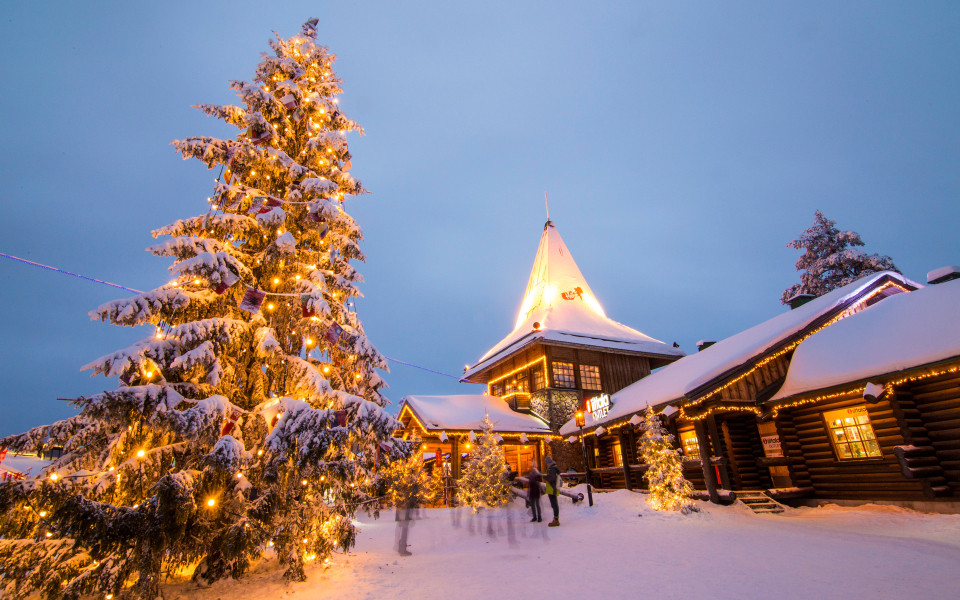 Beleuchtetes Weihnachtsmanndorf in Rovaniemi mit schneebedeckten H&auml;usern
